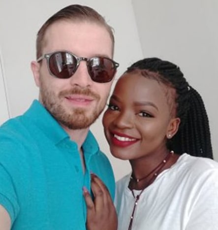 A black woman leans into her white male interracial partner for a happy relationship photo
